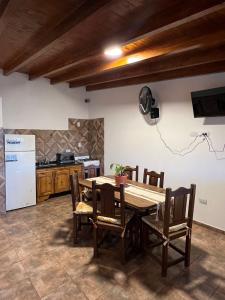 cocina con mesa, sillas y nevera en EL ENCANTO DEL COLIBRE en San Carlos
