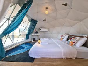 - une chambre avec un grand lit dans une tente dans l'établissement WC Coffee&ไร่หวานซึ้ง, à Mae Hong Son