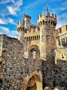 a large stone castle with turrets and a bridge at Tu Apartamento Ideal in Ponferrada