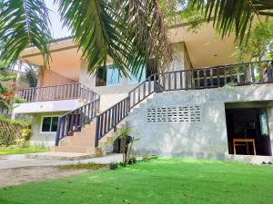 a house with stairs and a lawn in front of it at The Zohan Resort & Travel Agency in Wok Tum