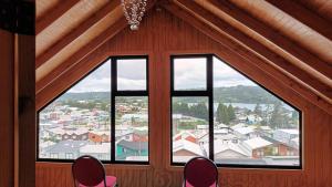 a room with two chairs and a large window at Cabaña piedra azul in Dalcahue