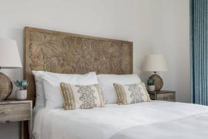 een slaapkamer met een wit bed met kussens bij The Lookout LR11 Lakeside Spa Holidays in Somerford Keynes