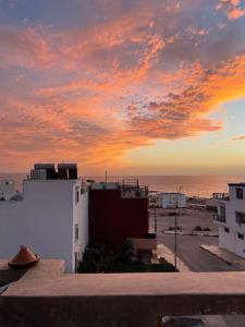 a sunset over the ocean from a building at ASNFU AUBERGe in Imsouane