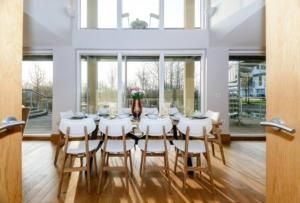 a dining room with a table and white chairs at Garden Villa CW70 HOT TUB Lakeside Spa in Somerford Keynes