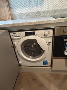 a washer and dryer under a counter in a kitchen at 1 BEDROOM FLAT IN WOOD GREEN PICCADILLY LINE in London