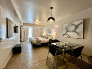 Habitación de hotel con cama, mesa y sillas en 460 LOFT Apartments en San Carlos de Bariloche