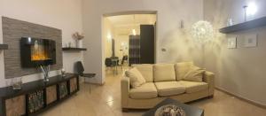 een woonkamer met een bank en een tv bij Casa Butera Sicily in Bagheria