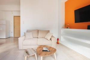 a living room with a white couch and a table at Colourful cosy apartment at Panormou metro station in Athens