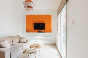 salon z kanapą i telewizorem w obiekcie Colourful cosy apartment at Panormou metro station w Atenach