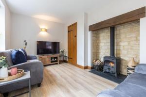 a living room with a couch and a fireplace at Badgers Lodge MV37 Lakeside Spa Property in Somerford Keynes