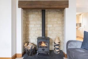 a brick fireplace with a stove in a living room at Badgers Lodge MV37 Lakeside Spa Property in Somerford Keynes
