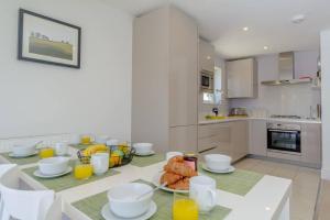 a kitchen with a table with breakfast foods and orange juice at Sundowner HM108 Lakeside Spa Property in Somerford Keynes