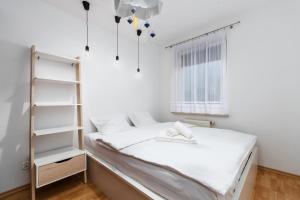 um quarto branco com uma cama e uma janela em Zabrodzka Family Apartment em Breslávia