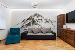 uma sala de estar com um mural de montanha na parede em Zabrodzka Family Apartment em Breslávia