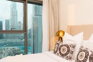 a bedroom with a bed and a large window at BURJ ROYAL-Luxurious 2 Bedrooms -DOWNTOWN-Burj & Fountain View in Dubai