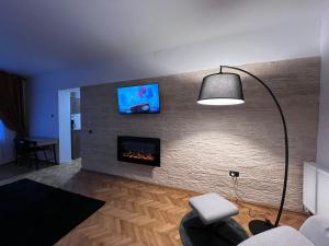a living room with a fireplace and a tv on a brick wall at Casa Basarab Brasov in Braşov