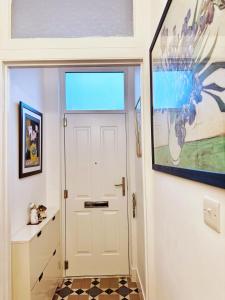 un pasillo con una puerta blanca y una ventana en London SW Holiday Apartment - Free parking en Londres