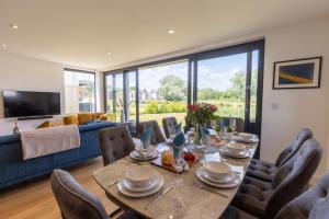 a dining room with a table and chairs at Mallards Way ML01 HOT TUB Lakeside Spa in Somerford Keynes