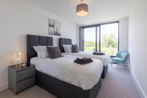 a bedroom with two beds and a desk and a window at Mallards Way ML01 HOT TUB Lakeside Spa in Somerford Keynes +46 photos