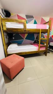 two bunk beds in a room with a stool at Kromatic Hostel in Medellín