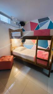 two bunk beds in a room with a chair at Kromatic Hostel in Medellín