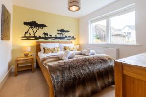 a bedroom with a large bed with a large window at Reflections HM77 HOT TUB Lakeside Spa NEW in Somerford Keynes