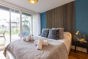 a bedroom with a large bed with blue walls at Reflections HM77 HOT TUB Lakeside Spa NEW in Somerford Keynes