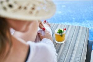 a woman sitting at a table with a drink at Hotel Sabbia d'Oro in Rimini