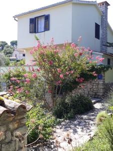 a house with pink flowers in front of it at Holiday Home Villa Esperanca in Veli Lošinj