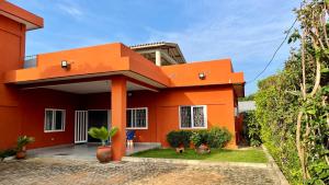 a red house with an orange at Les Amazones Rouges Chambre Bleue in Ouidah
