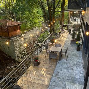 a patio with a table and chairs and lights at Bonvillas Brezovicë riverside apartments in Brezovica