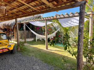 a hammock hanging from a pergola in a yard at Pousada Cavalo Bravo Preá Jeri in Prea