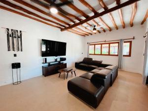 a living room with a couch and a flat screen tv at Casa Arena Holbox! in Holbox Island