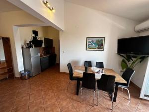 a dining room with a wooden table and black chairs at Grgo Apartments in Drage