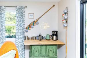 una cocina con un armario verde con ollas y sartenes en White Horse Cozy House -8 min walk to the beach!, en Plymouth