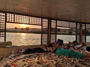 a group of children laying on a bed in a boat at Aswan Felucca sailing boat and Hotel in Aswan