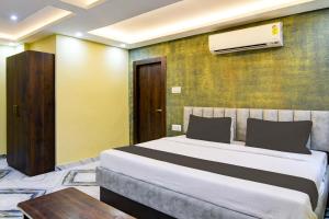 um quarto com uma cama e ar condicionado na parede em The Crown em Calcutá