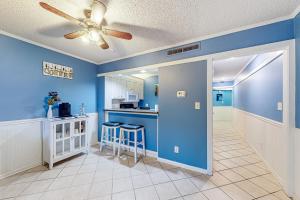 a kitchen with blue walls and a ceiling fan at Playa Flor de Cana in Myrtle Beach