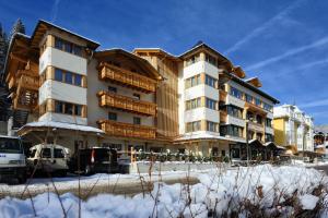 un grande edificio con neve di fronte di Hotel Crozzon a Madonna di Campiglio