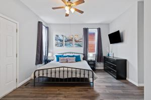 a bedroom with a bed and a ceiling fan at Exquisitely Designed Townhome - JZ Vacation Rentals in Saint Louis