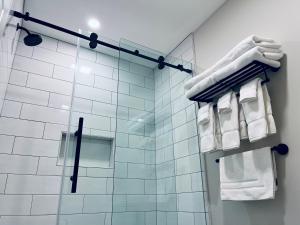 a bathroom with a shower with white towels at Saxon Inn in Alfred