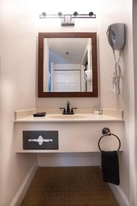 uma casa de banho com um lavatório e um espelho em Saxon Inn em Alfred