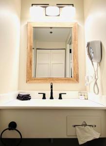 W łazience znajduje się umywalka i lustro. w obiekcie Saxon Inn w mieście Alfred