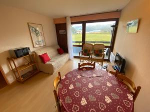 un salon avec une table, des chaises et un canapé dans l'établissement Appartement 37m² avec balcon, 500m centre village et pistes ski, parking privé - Autrans - FR-1-737-40, à Autrans