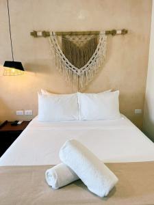 a white bed with a towel on top of it at Arena Apartment 1 in Holbox Island