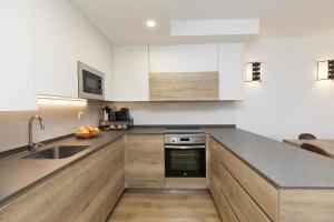 Una cocina con gabinetes blancos y un fregadero. en Casa Pareja by BeValle, en Panticosa 24 fotos más