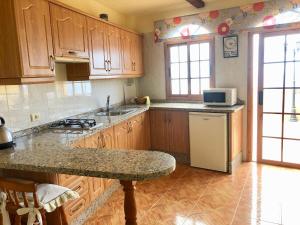 a kitchen with wooden cabinets and a granite counter top at VV APARTAMENTOS ESTRELLA DEL NORTE in Icod de los Vinos