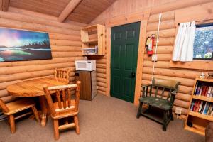 a dining room with a green door and a table and chairs at Experience Montana Cabins - Birdsong #2 in Bigfork