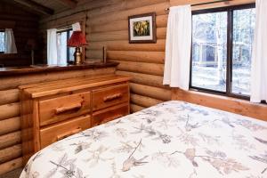 a bedroom with a bed in a log cabin at Experience Montana Cabins - Birdsong #2 in Bigfork