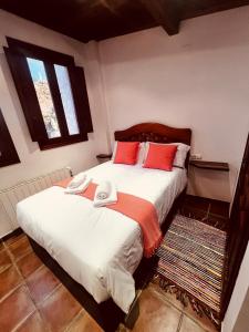 a bedroom with two beds with red pillows at Rascacielos San Martín in Cuenca
